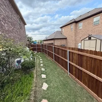 Brown stained wood privacy fence with metal posts along residential property