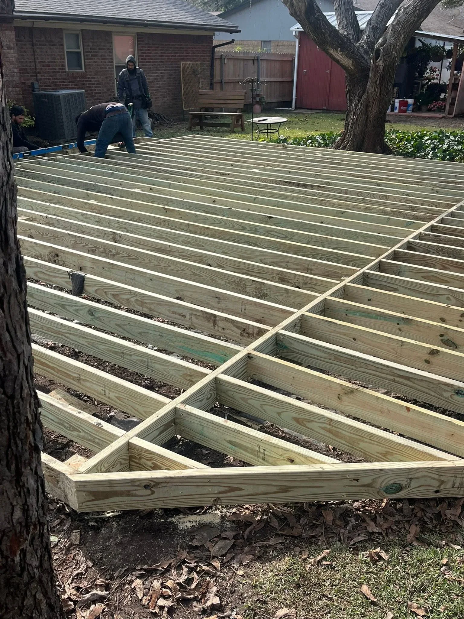 Pressure-treated wood deck framing with joists and beams during construction