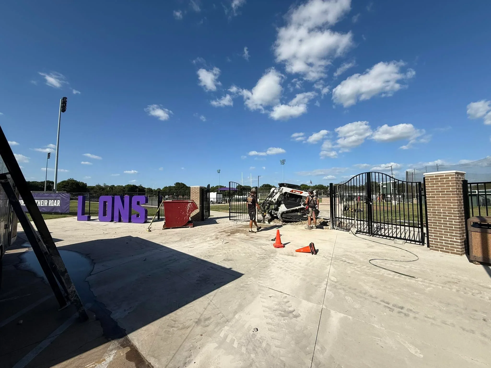 Black steel ornamental fencing with gates around sports complex perimeter