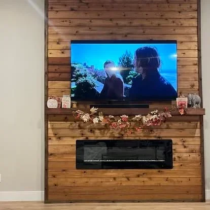 Horizontal shiplap wood wall with mounted TV and black fireplace insert