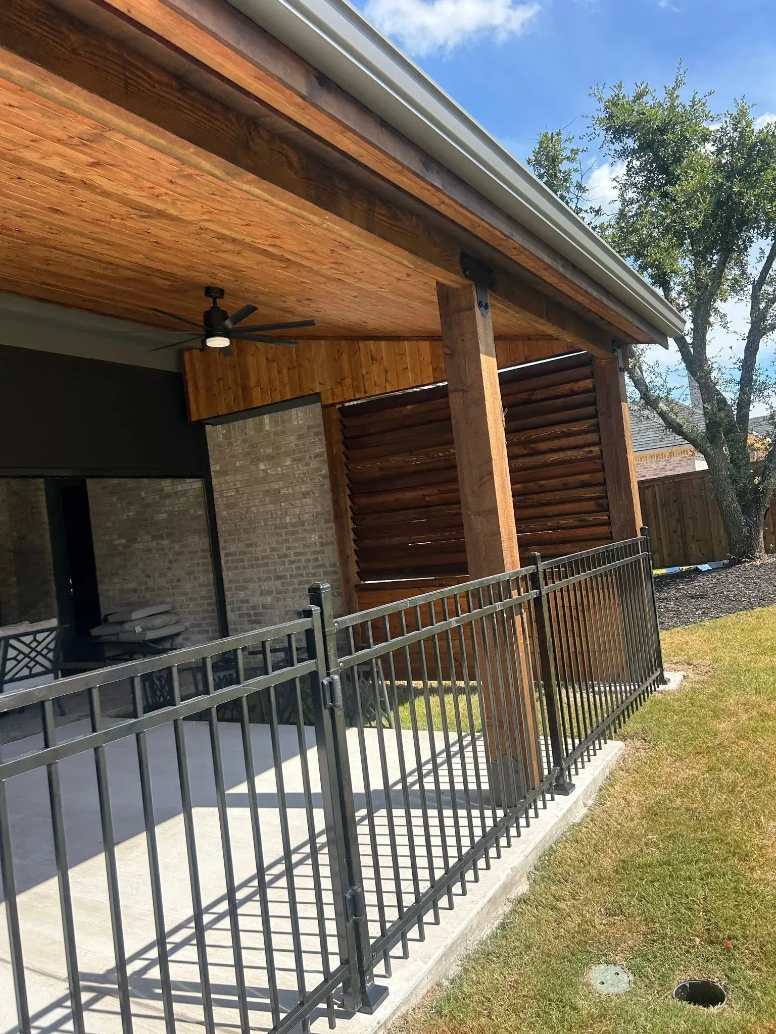 Composite deck with metal railing, wood beam pergola, and horizontal privacy screens
