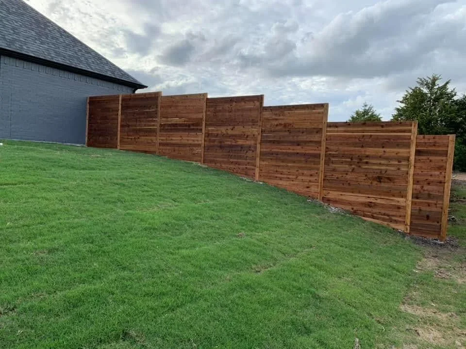 Horizontal wood privacy fence with treated timber panels and posts installed on residential property