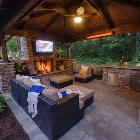 Covered patio with timber beams, fireplace, TV, and wicker seating furniture