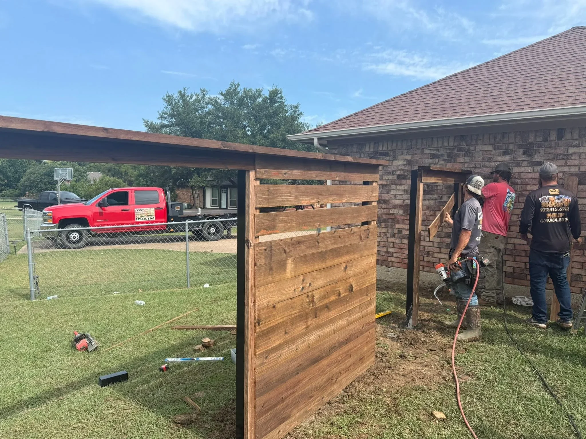 Horizontal wood fence with stained timber boards and steel frame posts during installation