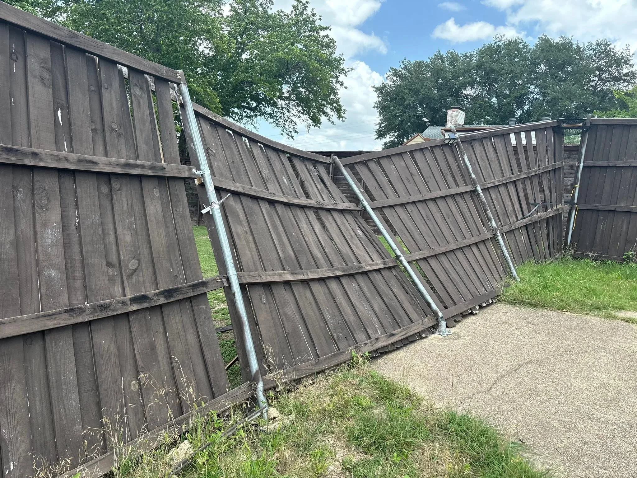 Weathered wood fence panels with galvanized steel diagonal bracing reinforcement