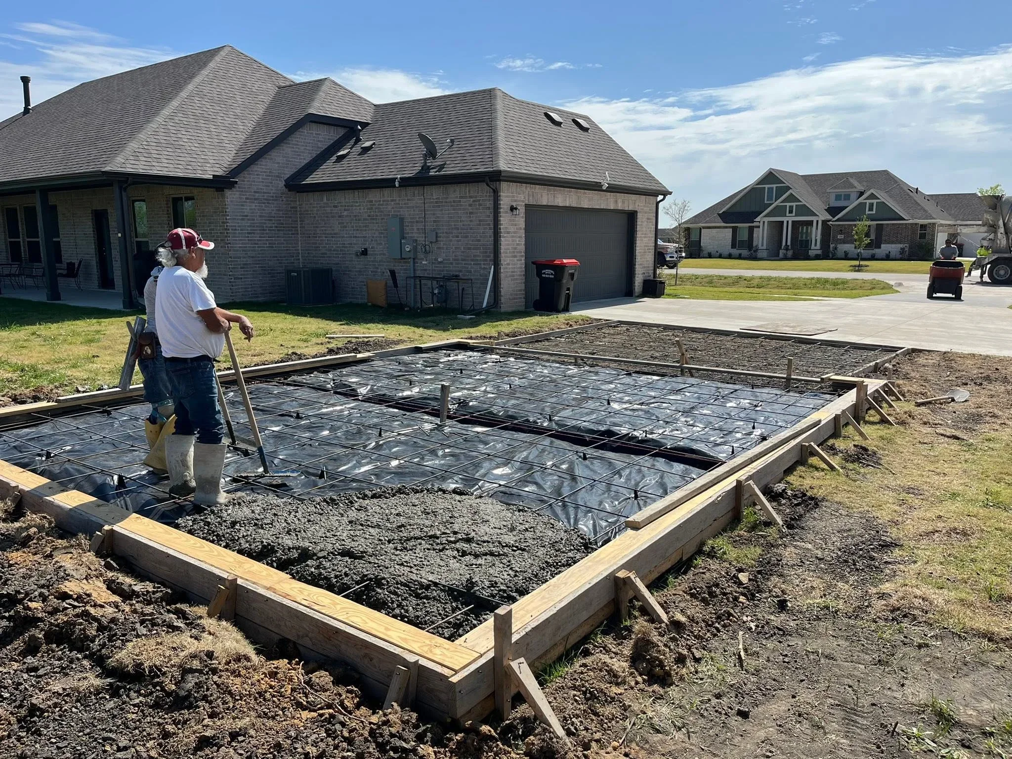 Concrete foundation pad with wooden frame, landscape fabric, and gravel base preparation