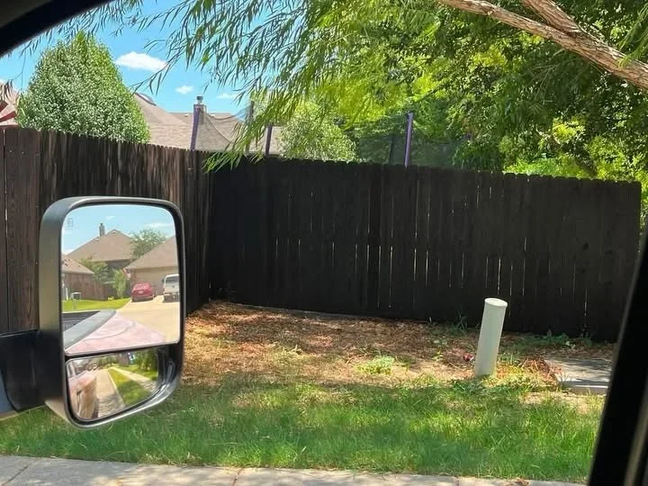 Dark wood privacy fence with vertical boards installed around residential backyard
