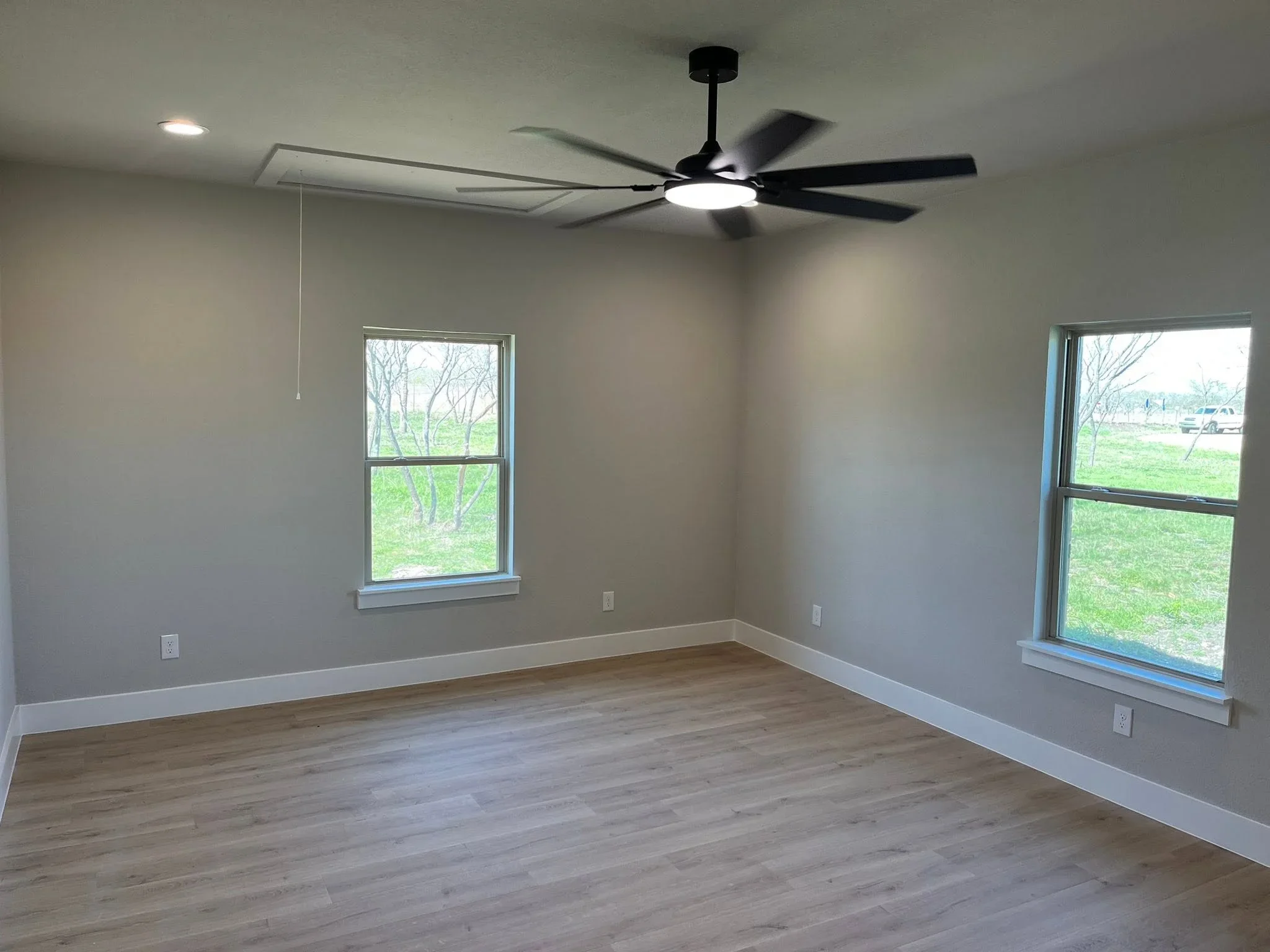 Interior room with drywall, recessed lighting, ceiling fan, vinyl plank flooring, and windows