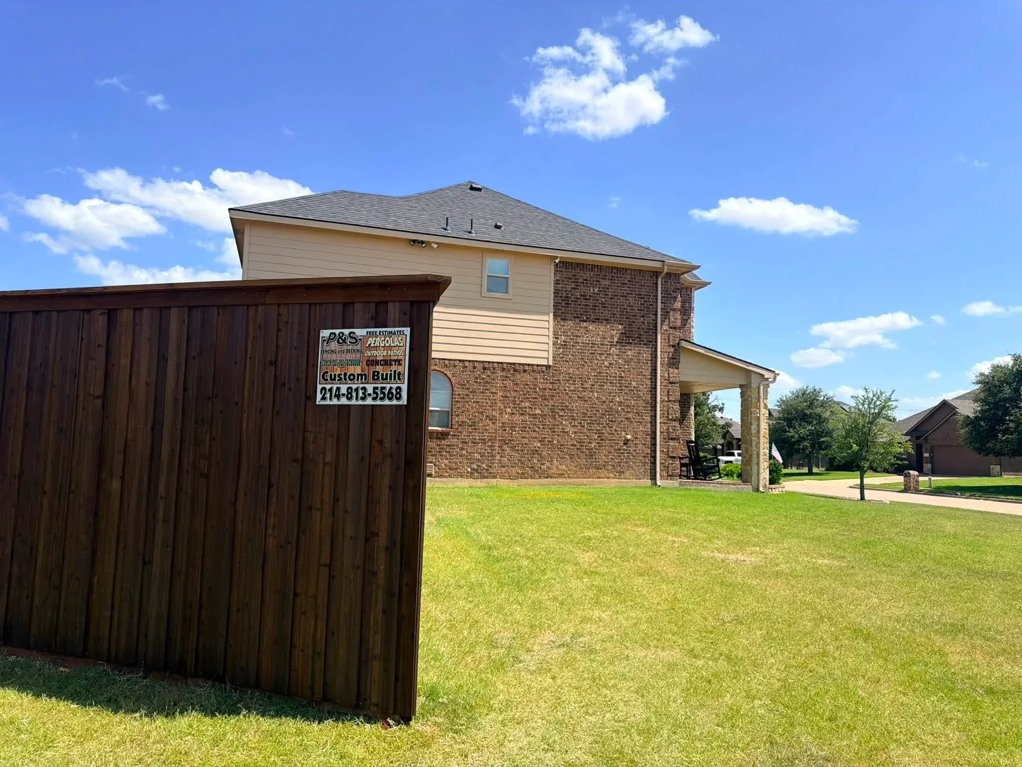 Dark-stained vertical wood fence with uniform board spacing installed at residential property