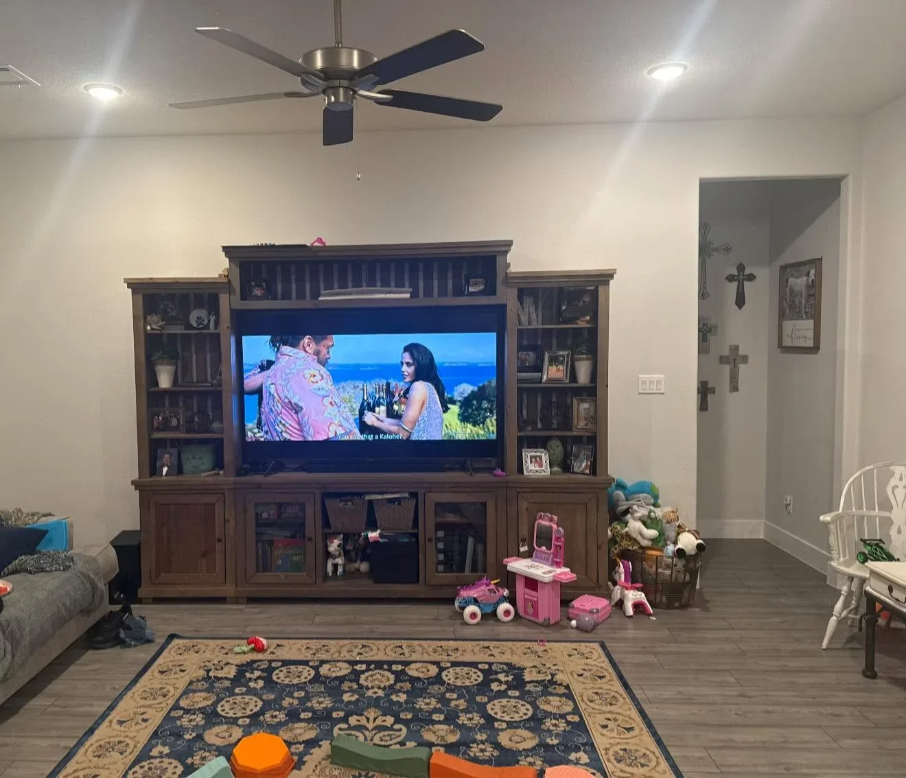 Custom wood entertainment center with built-in shelving, TV mount, and storage cabinetry