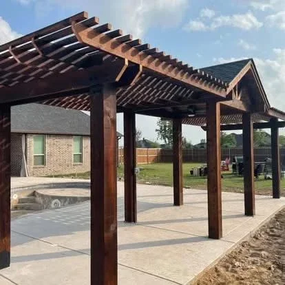 Dark-stained wood pergola with beam construction over concrete patio